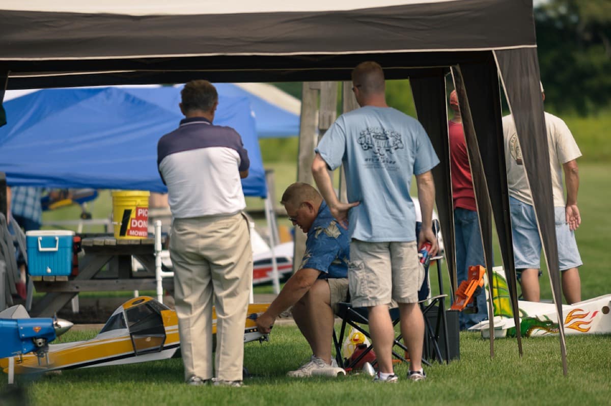 Club members helping each other with a model plane in the pits